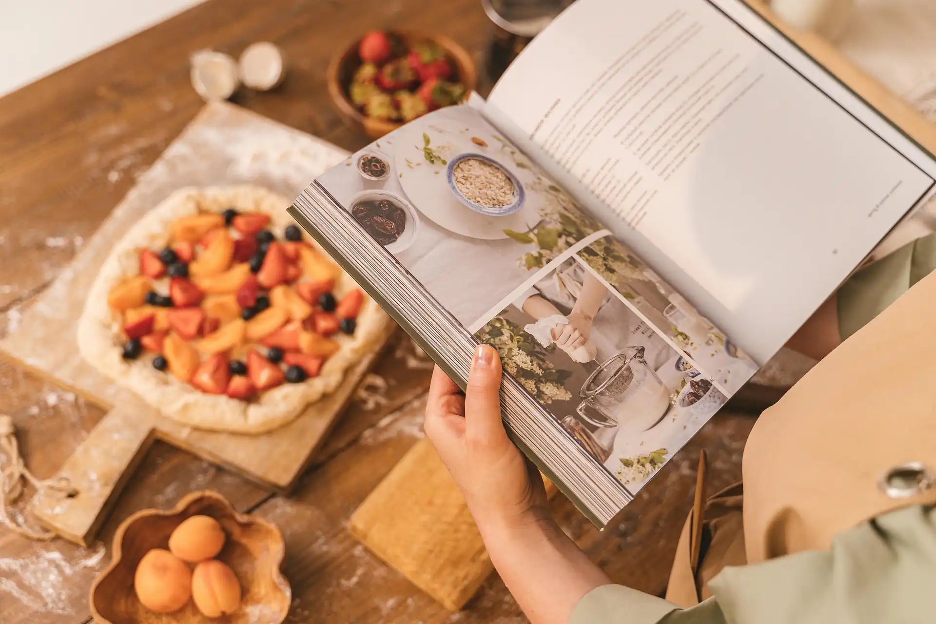 Reading a printed family cookbook at the kitchen table